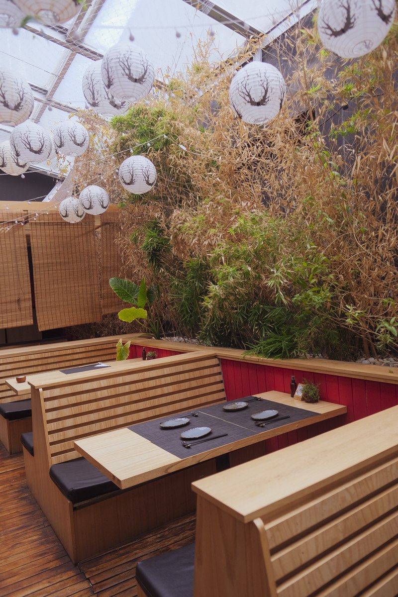 Sector jardín de Harakiri de Una — bancos de madera, bambú y linternas japonesas