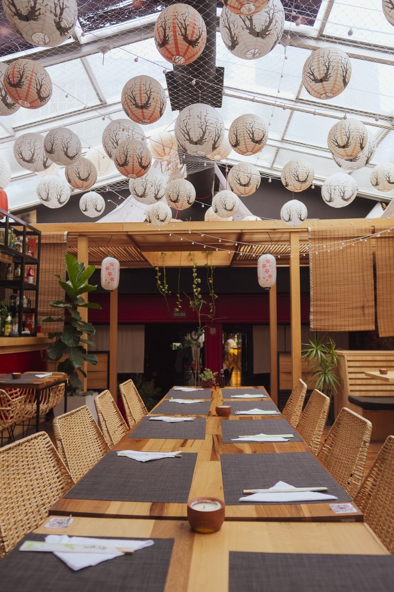 Salón principal de Harakiri de Una — linternas chōchin y mesa larga preparada para evento