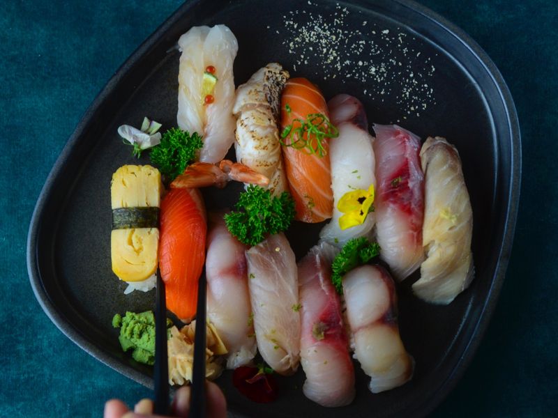 Hand with chopsticks over omakase at Harakiri de Una