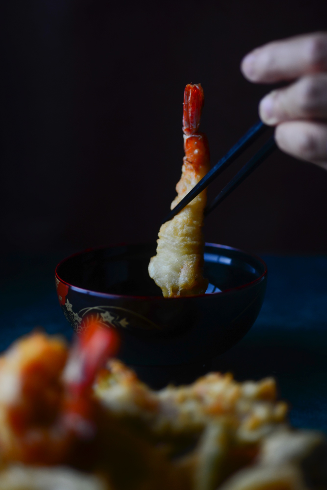 Langostino en tempura con palillos sobre cuenco lacado en Harakiri de Una